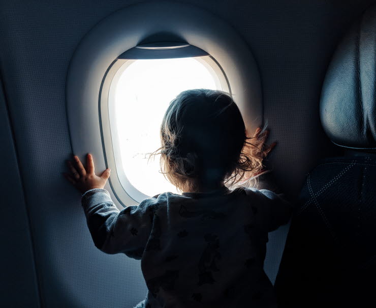 Child looking out through aircraft window