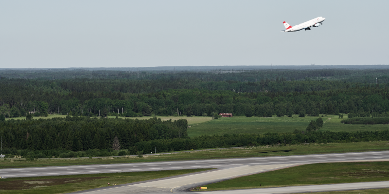 Ett flygplan har just lyft och ett taxar ut på startbanan på Arlanda