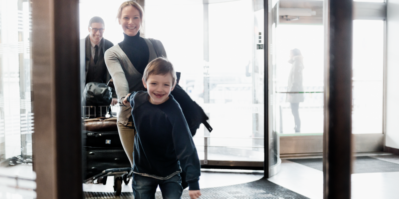 Boy holding woman's hand at the entry of a terminal at Stockholm Arlanda