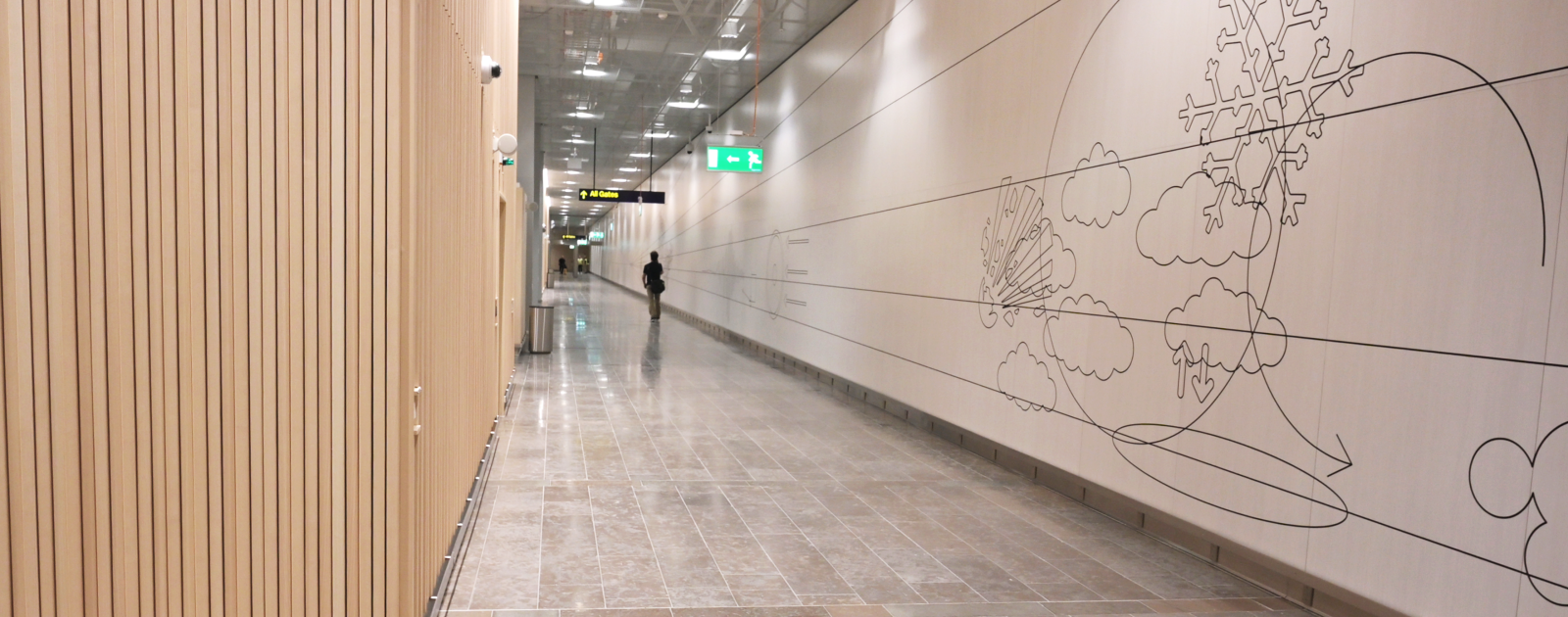 A traveller walking down the art corridor behind the new security check in Terminal 5.