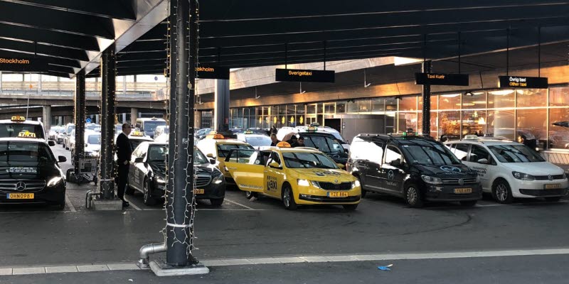 Taxibilar som står parkerade under ett tak