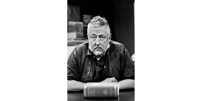A photo of Leif GW Persson with the Swedish law book in front of him
