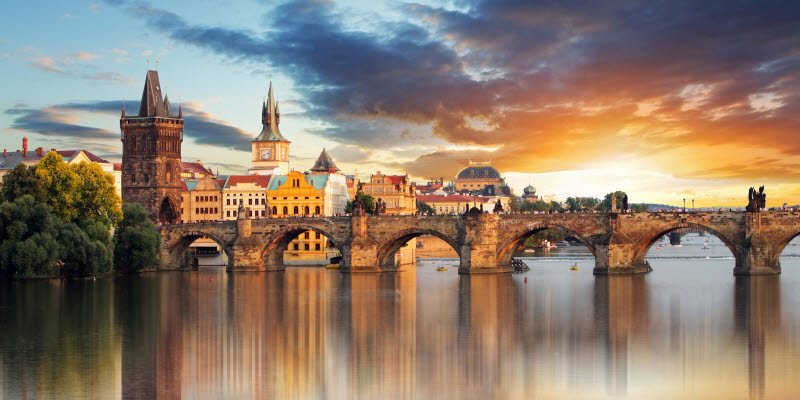 Vy över å och gammal bro i Prag