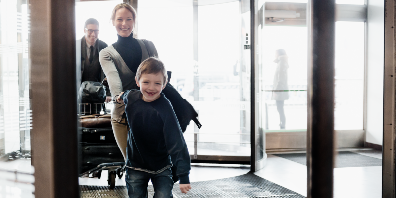 En förväntansfull familj går in på flygplatsen