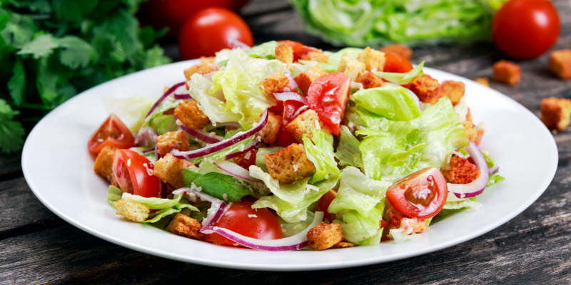 White plate with salad and tomatoes