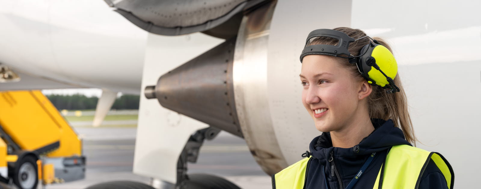 En kvinnlig medarbetare framför en flygplansmotor