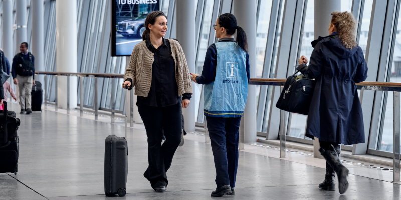 A female traveler talks to a terminal host in SkyCity.