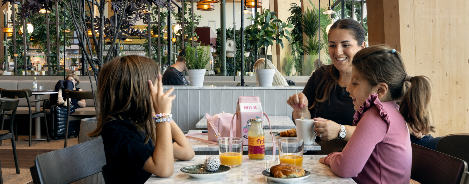 Woman and two children are eating at restaurant in airport