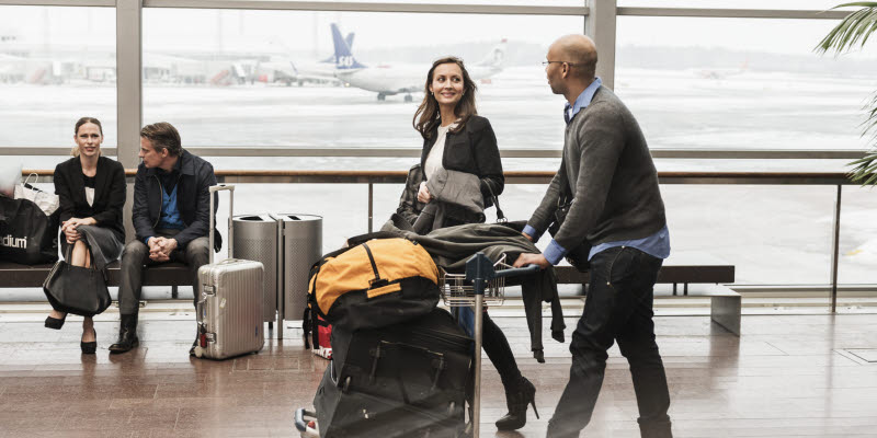 Two travelers with a luggage carrier