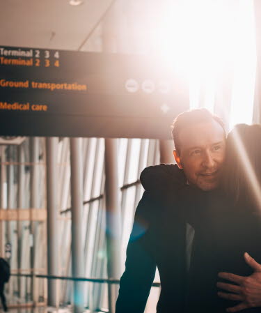 A couple hugging each other at the airport