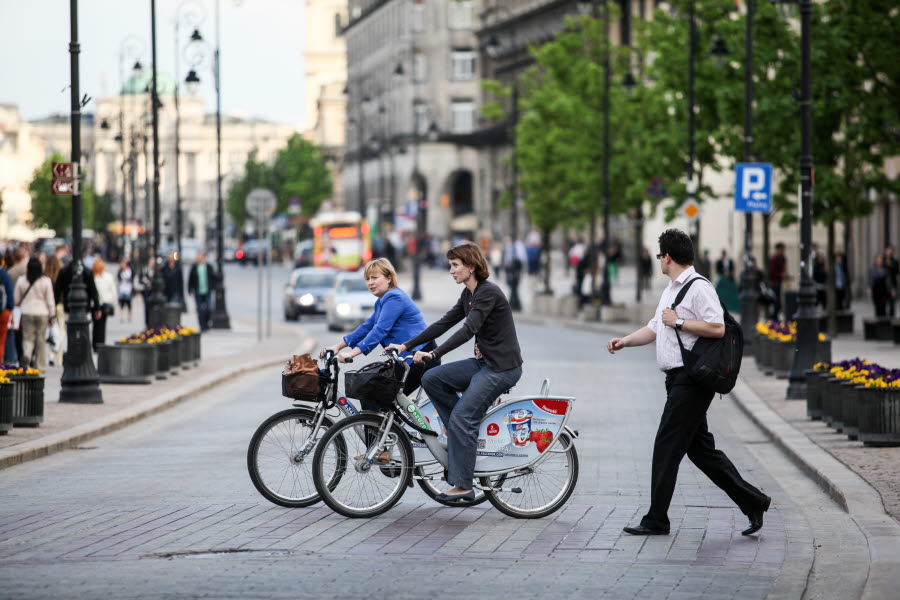 Två cyklister korsar en väg i Warszawa