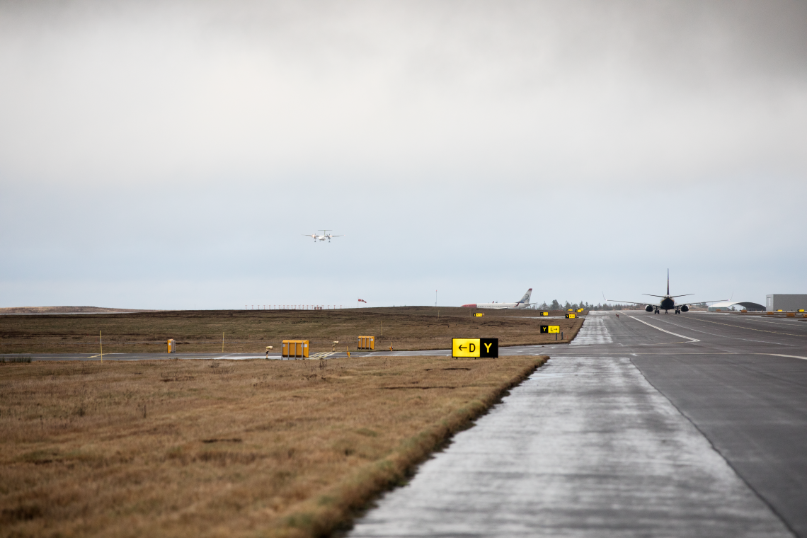 A view of taxiing aircrafts and an approaching turboprop