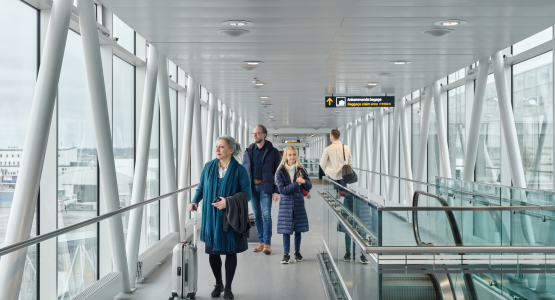 Resenärer med väskor går i gate-området.