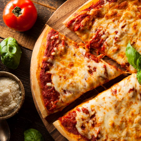 Ost- och tomatpizza på en träbricka.