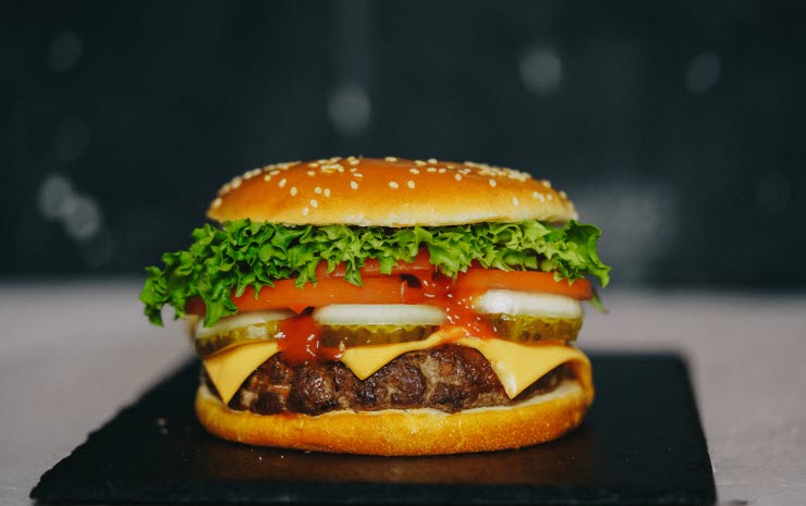 Hamburgare med sallad, tomat, lök, pickles och ost.