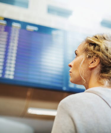 A person looking at board with arrivals or departures at Arlanda