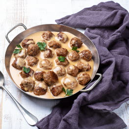 Meatballs in brown sauce in a pan.