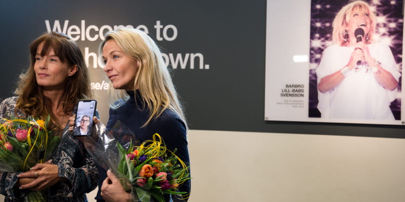 Malin Berghagen och Kristin Kaspersen står framför Lill-Babs porträtt i Welcome to my hometown