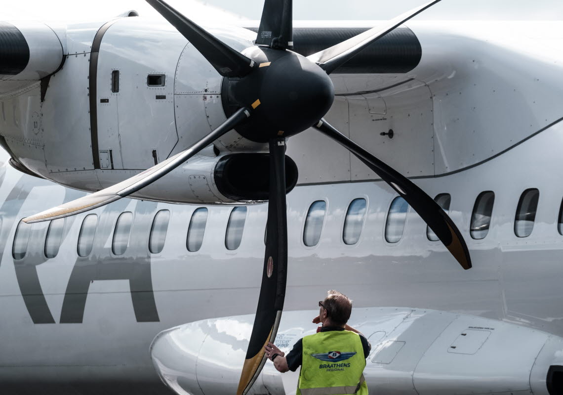 Man kontrollerar rotorbladen på en flygplansmotor.