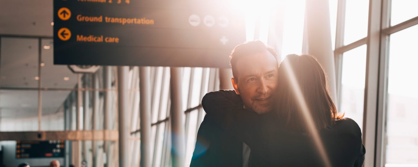 A couple hugging each other at the airport