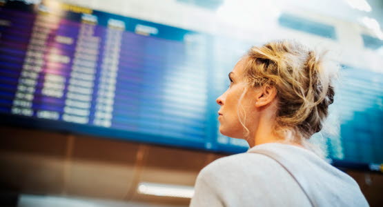 A person looking at board with arrivals or departures at Arlanda