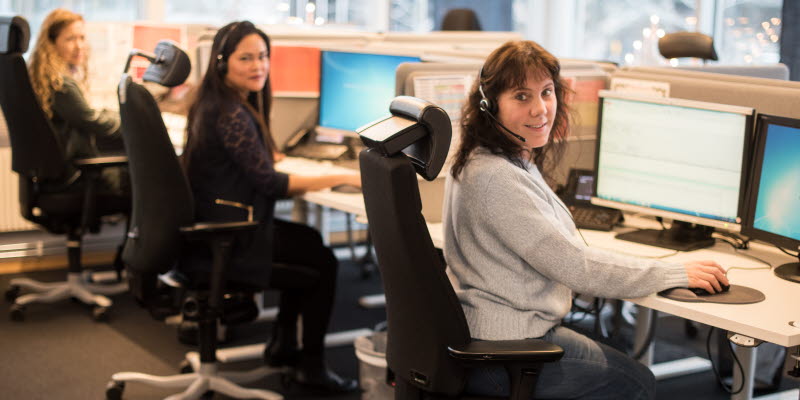 Tre kundtjänstmedarbetare sitter framför varsin datorskärm