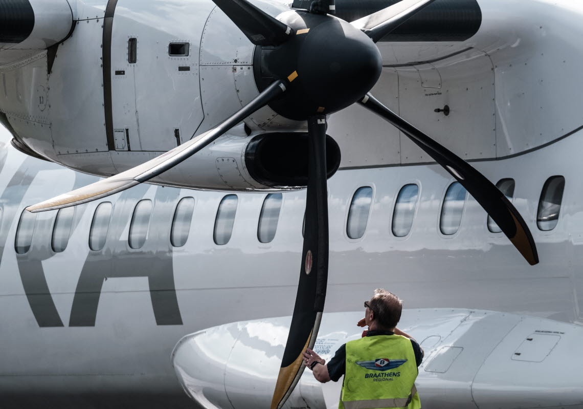 Man checking rotor blades of an airplane motor.