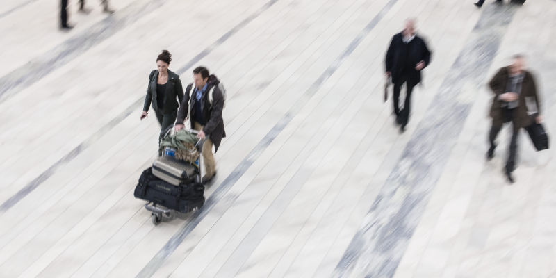 Människor med bagage gående på stengolv