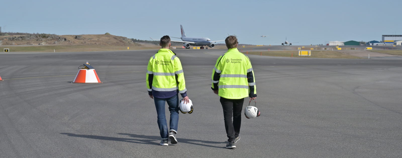 Two men walking in an airfield