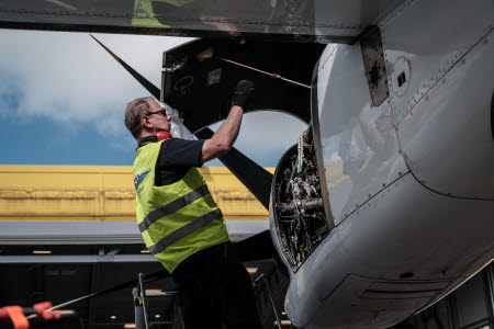 En man kontrollerar en flygplansmotor
