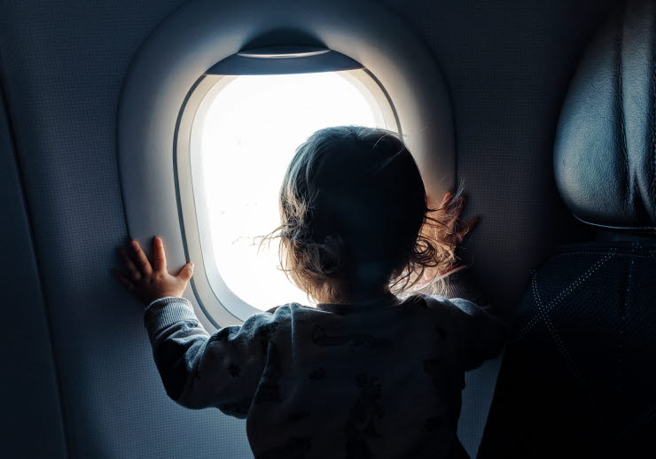 Barn som tittar ut genom flygplasfönster