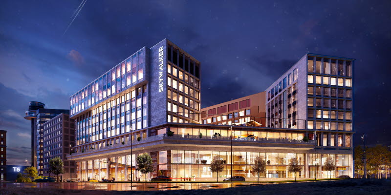 Multiple storey hotel with lights shining from all windows during dusk.