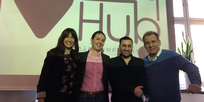 Four people standning in front of a sign saying Entry Hub