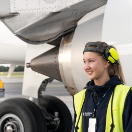 En kvinnlig medarbetare framför en flygplansmotor