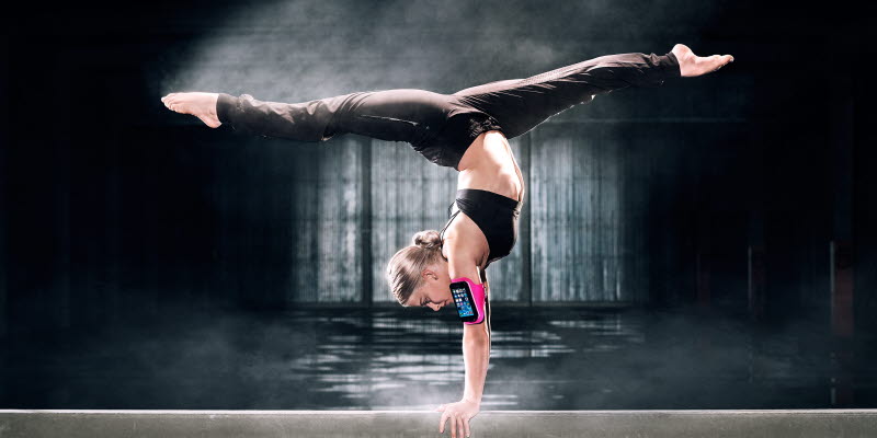 Gymnast i split med telefon på armen