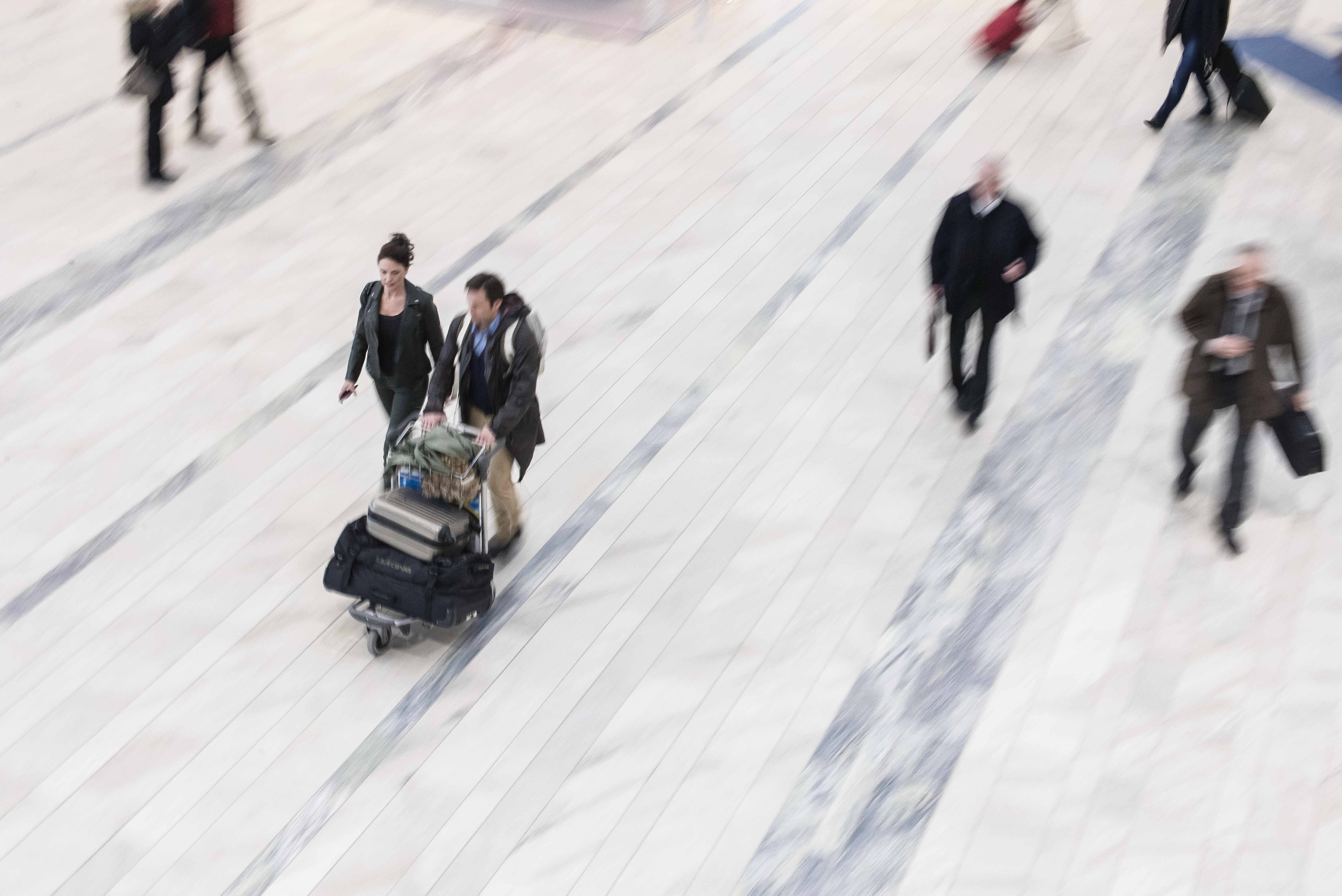 Människor med bagage gående på stengolv