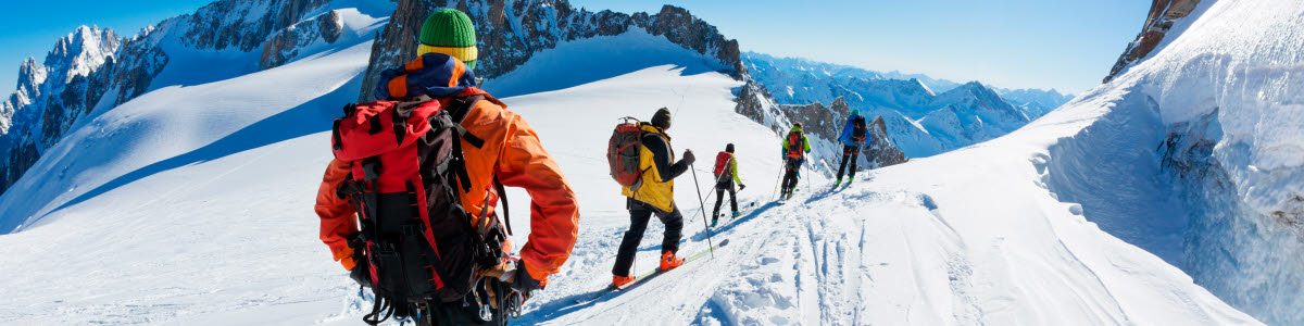 A group of skiers start the descent of Valle Blanche, the most famous offpist run in the Alps, Valle Blanche descent links Italy and France through the Mont Blanc Massif. Chamonix, France, Europe.