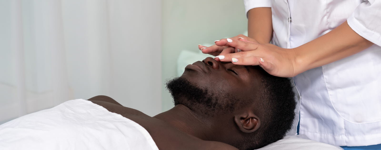Woman giving a man a face massage.
