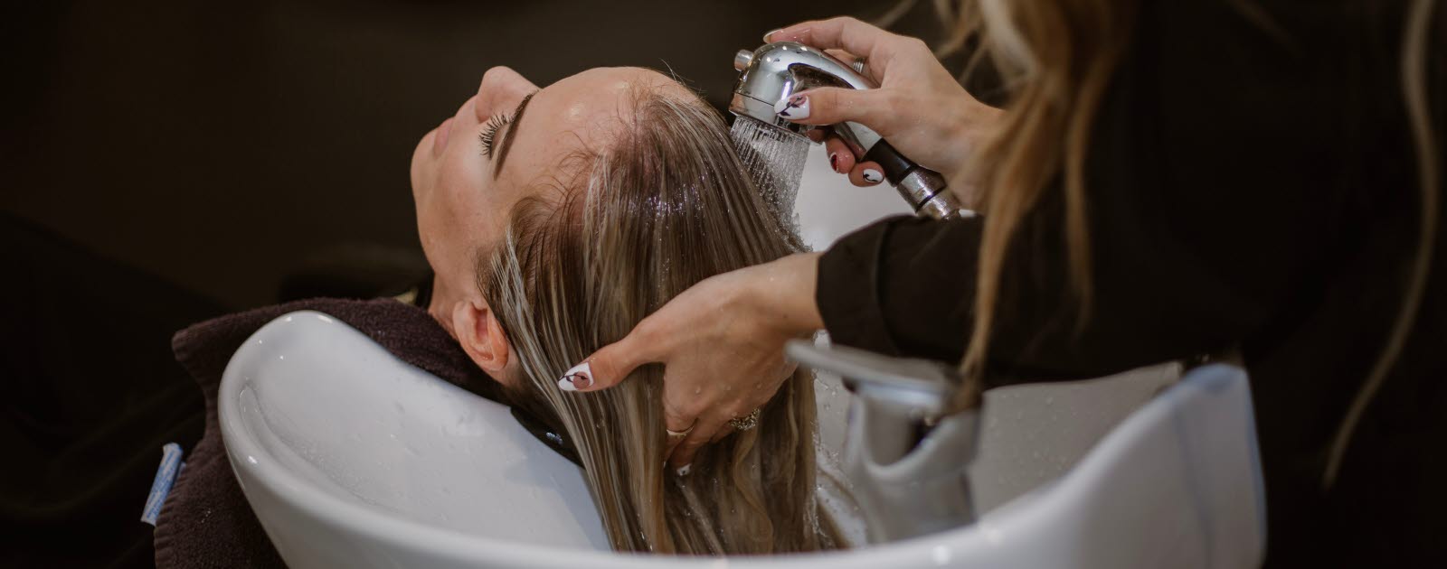 Hairdresser washing a woman's hair.