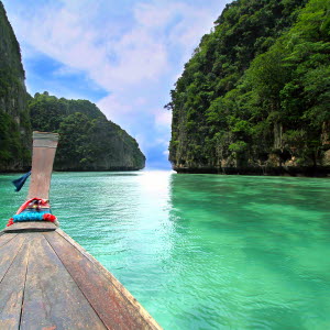 Båt på turkost vatten omgiven av vacker natur, Phuket