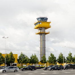 The control tower at Malmö Airport with paked cars in front